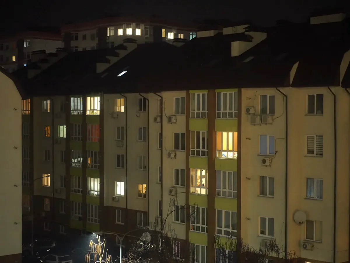 Apartment building at night with lights going out and returning